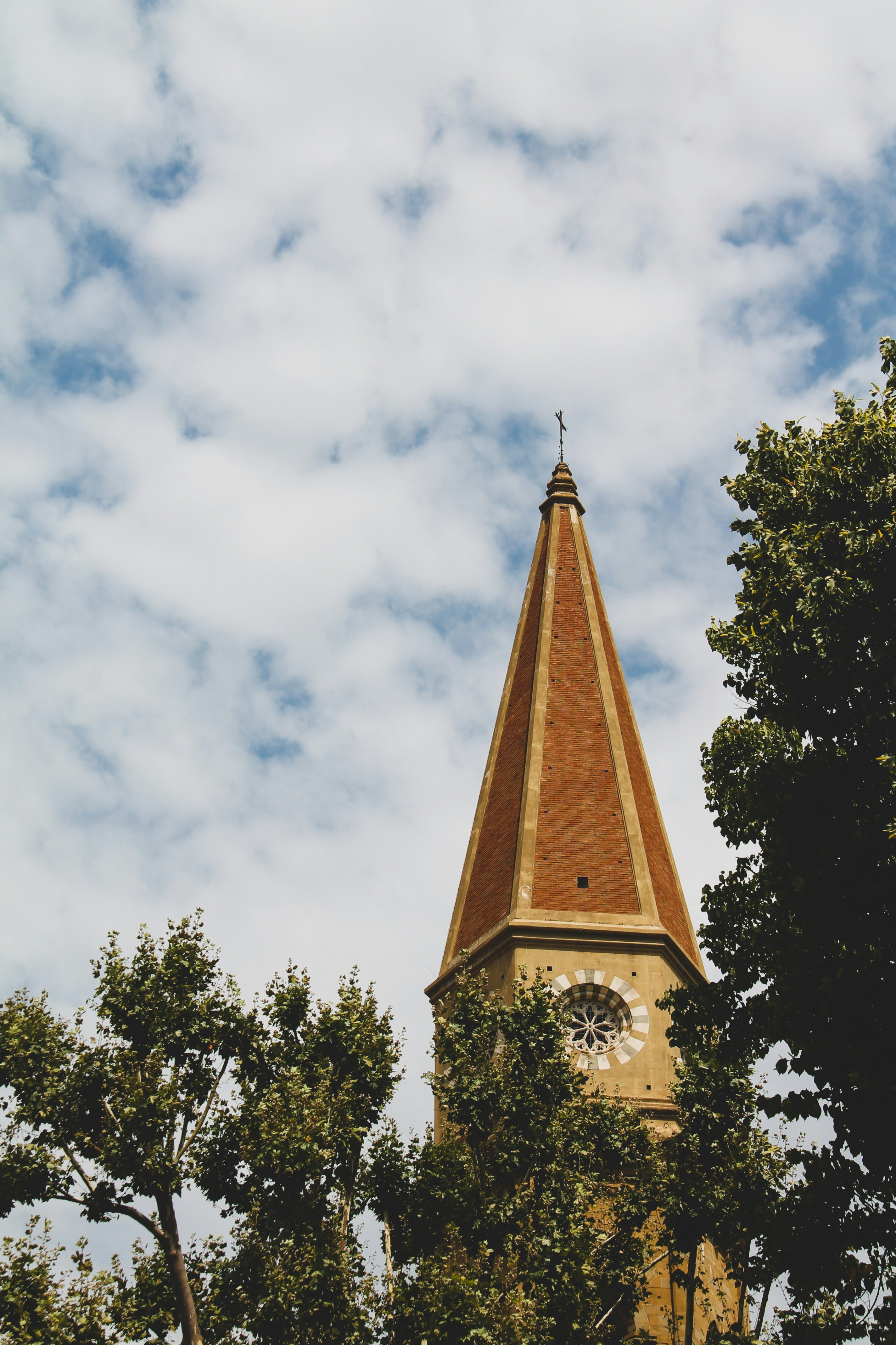 brown concrete tower under white clouds